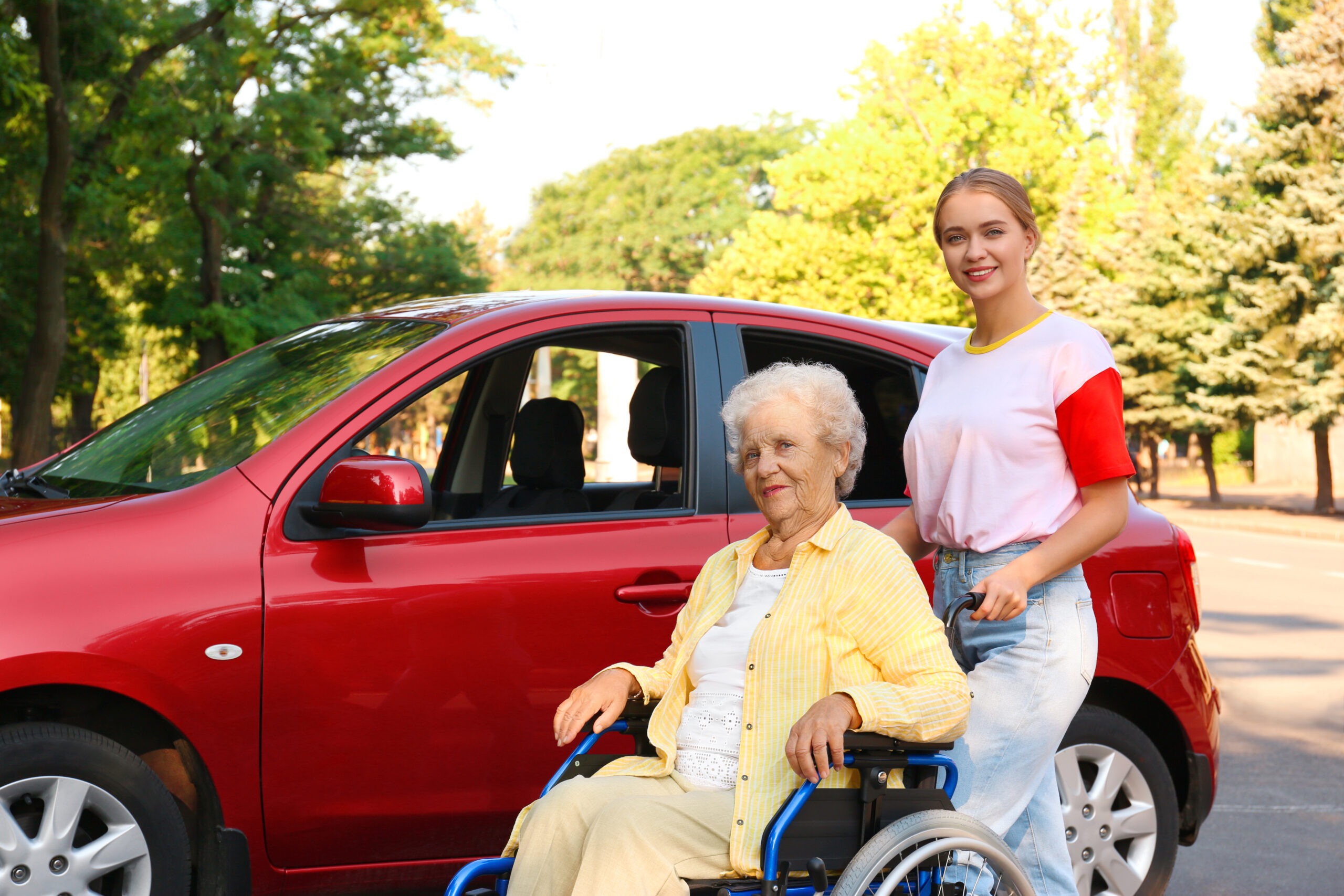 A senior disabled woman being assisted outdoors, highlighting accessible travel support from holiday companies for disabled people at Accessible Travelling.