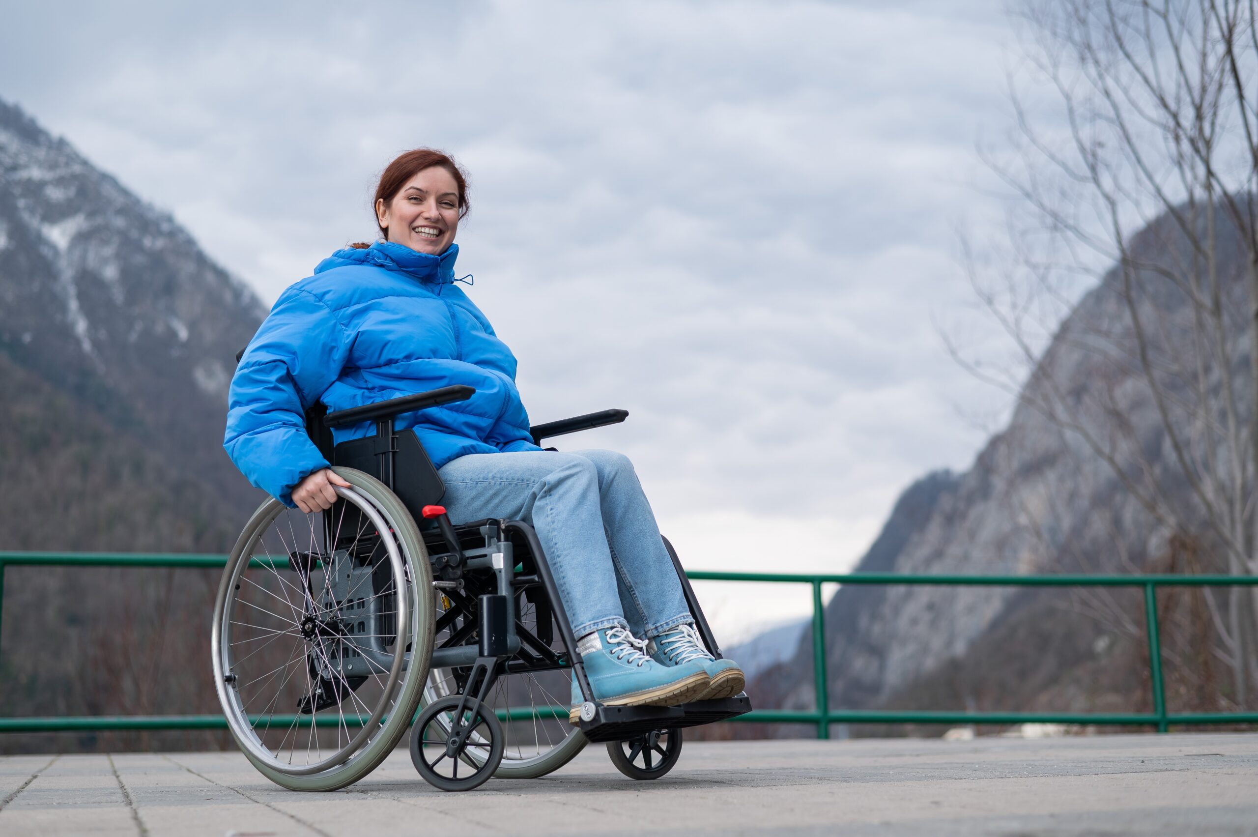 A disabled woman trusts the ultimate resources from a holiday company for disabled people while enjoying a scenic mountain travel experience at Accessible Travelling.