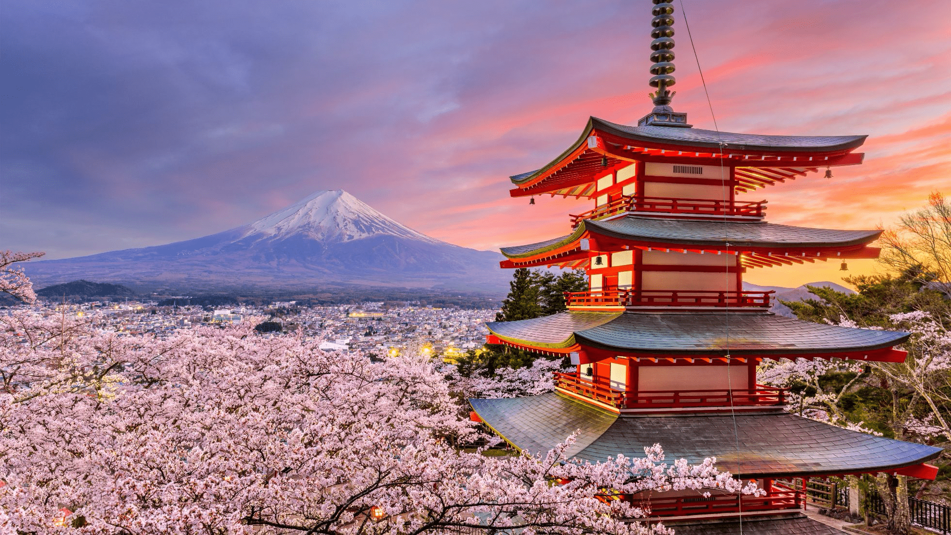 Cherry blossoms frame a traditional pagoda with Mount Fuji in the background, capturing Japan's iconic spring scenery.