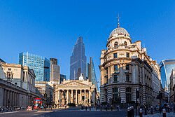 Historic buildings juxtaposed with modern skyscrapers in London's financial district, showcasing the city's architectural diversity and urban development.